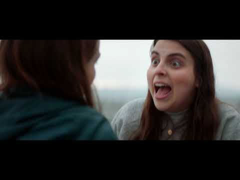 Booksmart final restricted trailer still—Molly and Amy in graduation jumpsuits, neon party glow