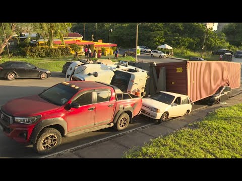Two vehicles damaged after container truck overturns