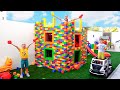 Vlad dan Niki bermain dengan balok mainan berwarna dan membangun rumah tiga tingkat