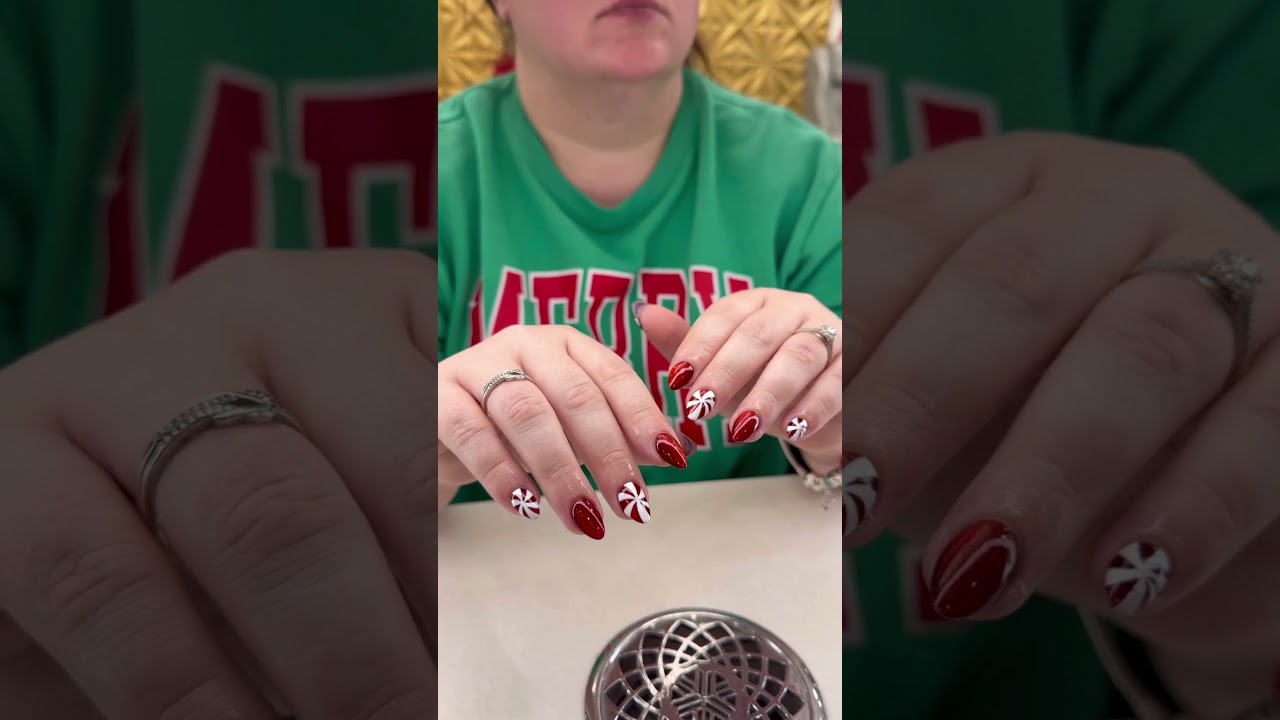 This nail design features red tones with Christmas candy accents