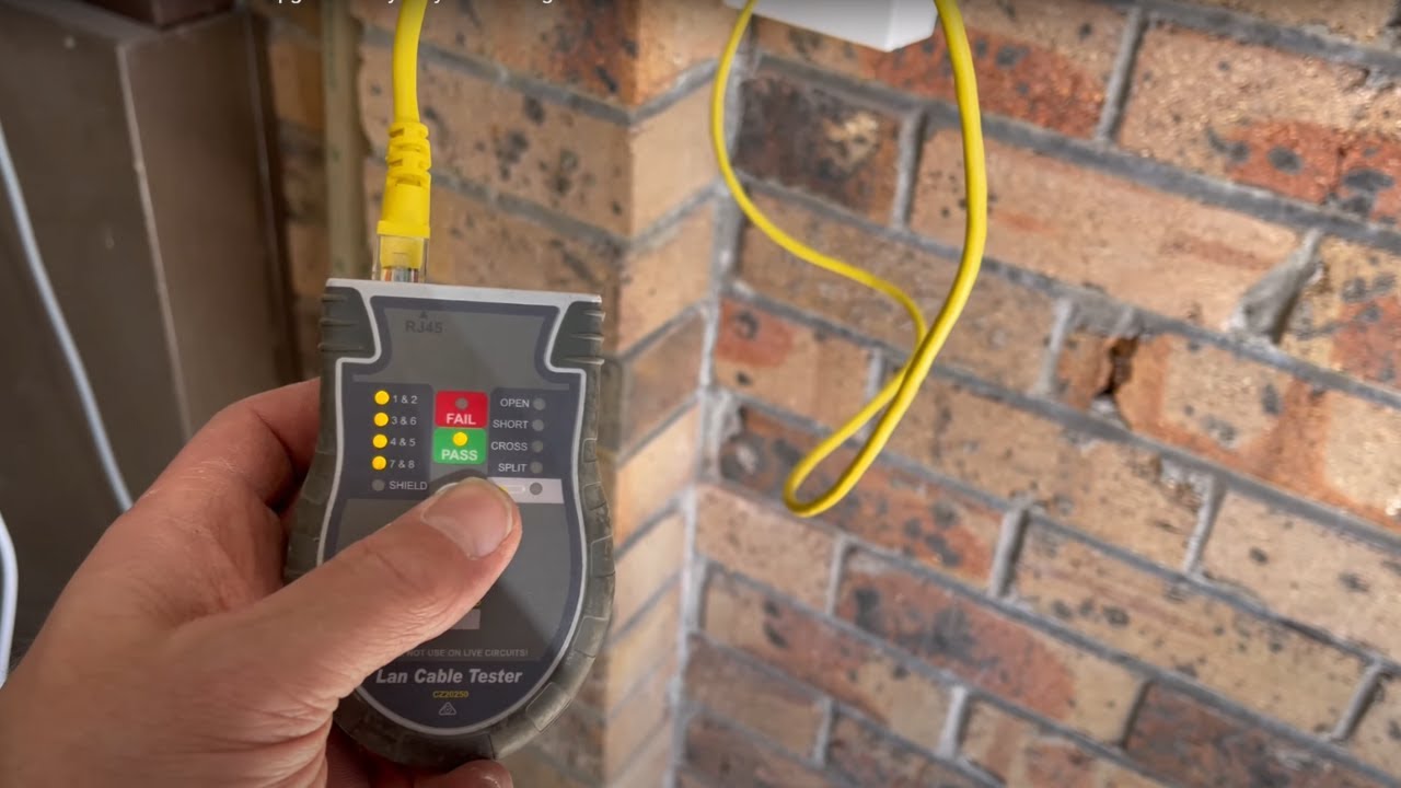 Jason from SECURE A COM running Cat 6A cable from garage NTD to new internal wall socket during NBN FTTP free fibre upgrade — single-skin brick wall assessment