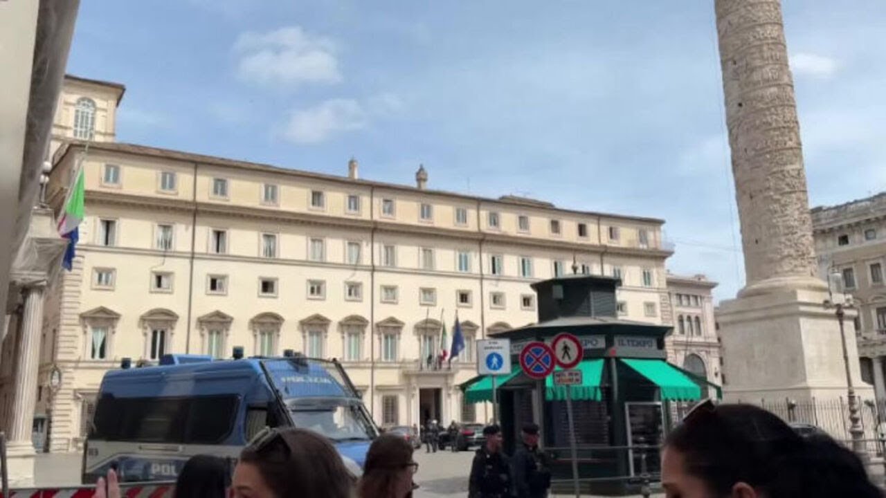 La bandiera libica viene sistemata sul balcone di Palazzo Chigi per la visita del premier Dbeibeh