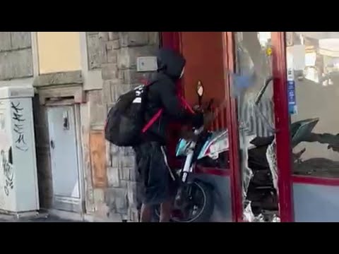 A FIRENZE un uomo distrugge la VETRINA di una concessionaria di MOTO sotto gli occhi dei passanti
