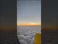 flying above clouds while the sun sets. you can see curvature of earth