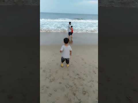 Baby play in the waves in marina beach