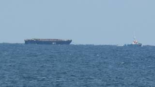 Boats on the horizon TMS BOOJUM BAY towing a hulk 20260511