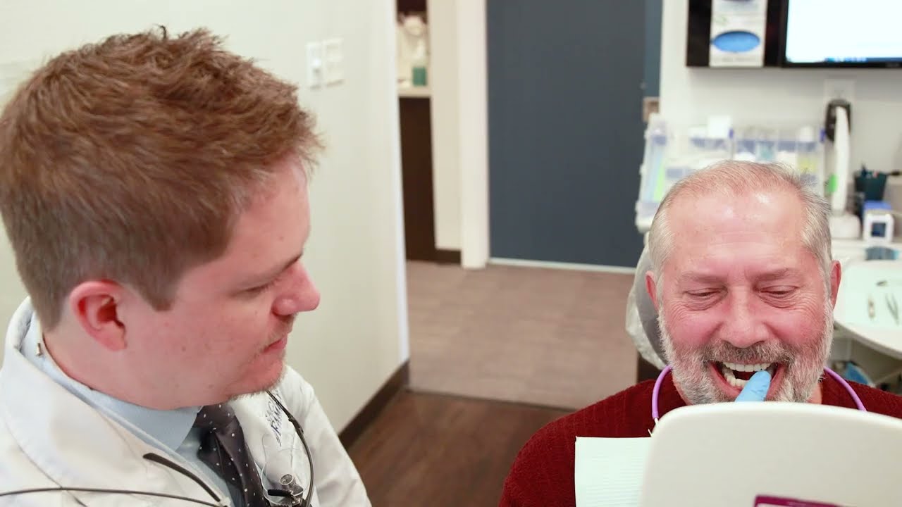 Dental team member laughing with a patient