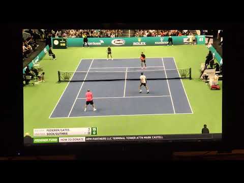 Roger Federer plays a point on his knees.