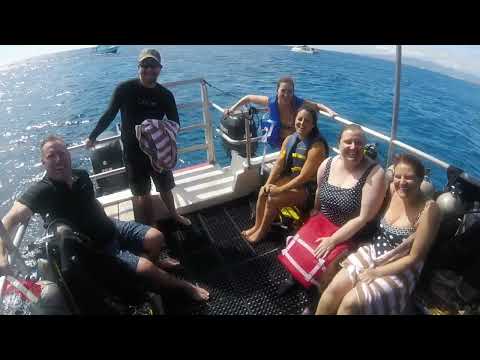 SCUBA divers leaping from a Rainbow Scuba boat into the ocean near Honolulu, Oahu.