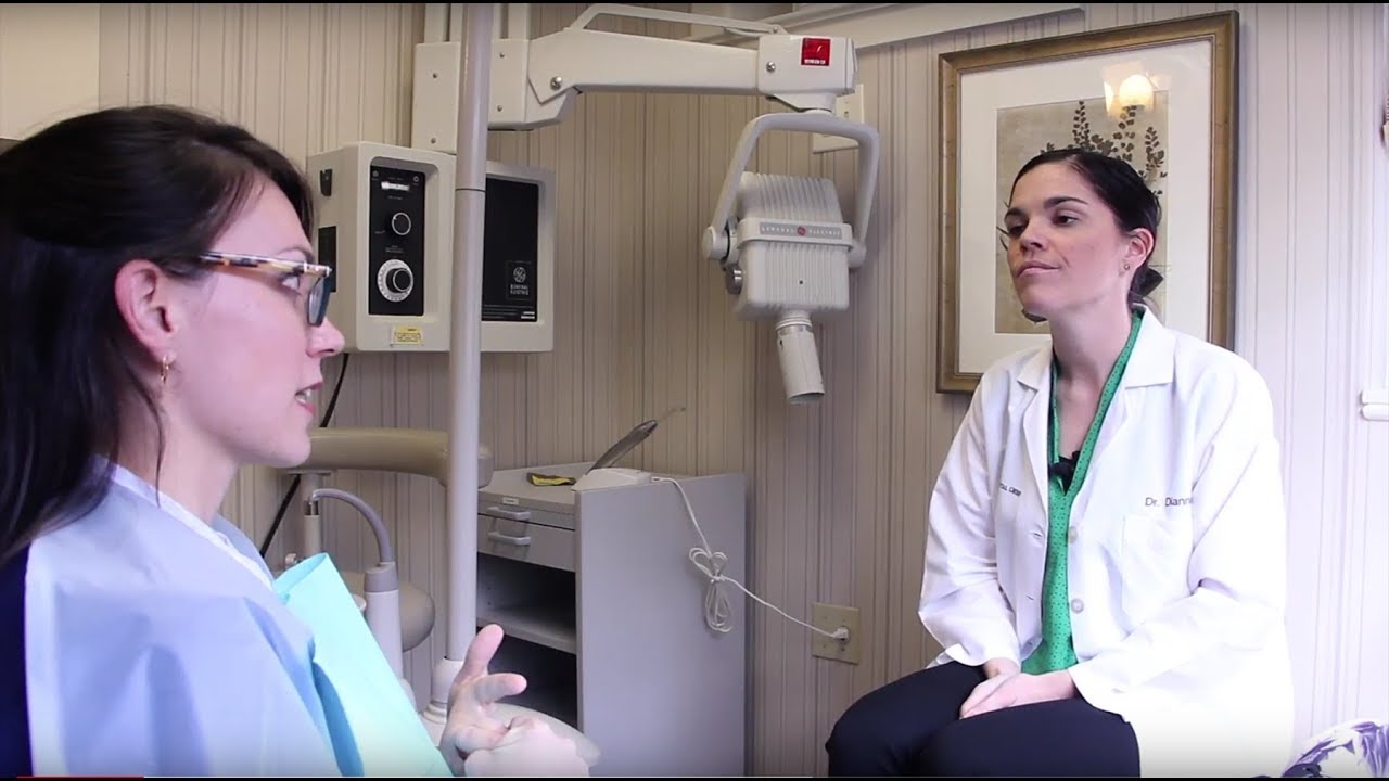 Woman in dental chair talking to cosmetic dentist