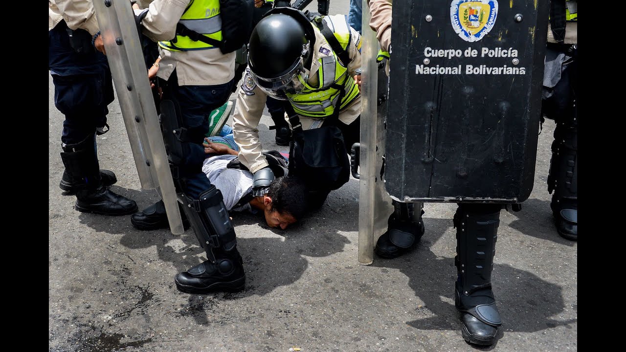 A picture of Venezuelan police arresting a protester.