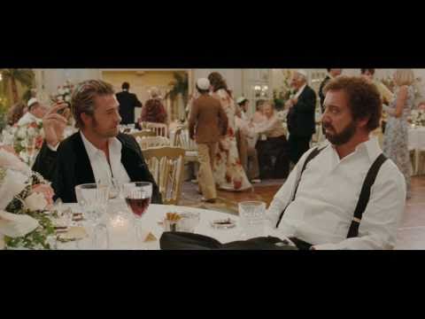 UK trailer thumbnail showing Rosamund Pike and Paul Giamatti in a warm-lit close-up