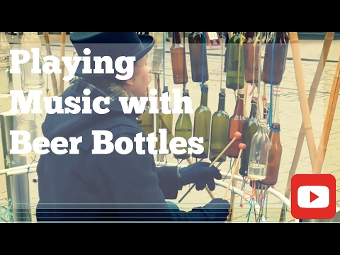 Man who plays music with half filled beer bottles.