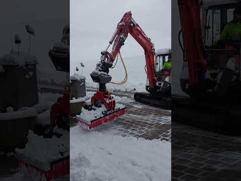 Schnee räumen mit Bagger und Kehrbesen