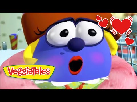 Blue VeggieTales character with a surprised expression, blush on cheeks, logo 'VeggieTales' bottom left, and hearts in the corner.