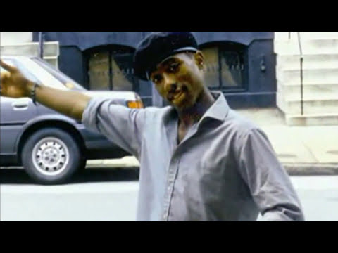 Trailer image of Tupac on stage, spotlighted, echoing the album’s live-wire energy