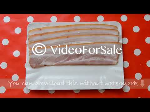 Person puting slices of bacon. Close-up top view.