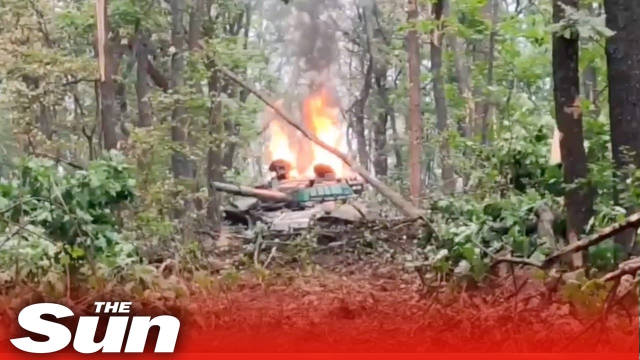 Tanque russo explodido em pedaços queima enquanto pára-quedistas ucranianos assistem
