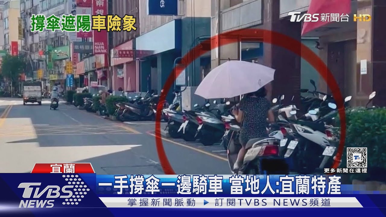 一手撐傘一邊騎車!當地人:宜蘭特產