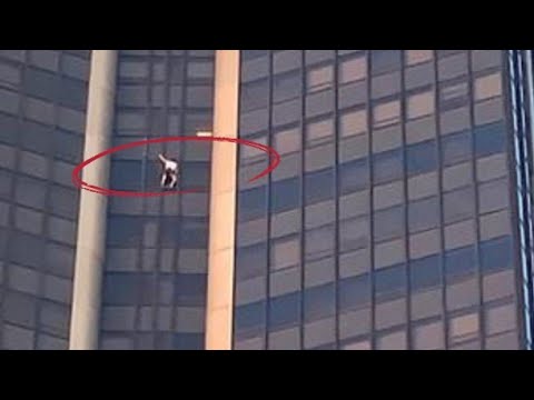 Daredevil climber without any safety equipment use his bare hands to climb up the tallest skyscraper