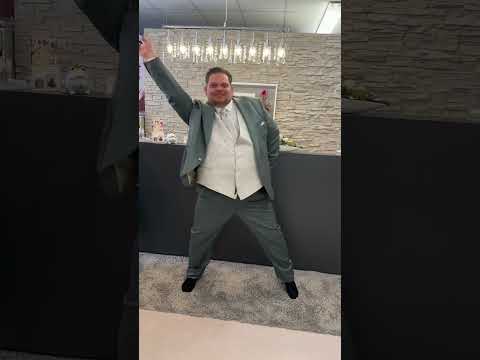 Bräutigam mit großer Größe tanzt vor Freude über seinen coolen Anzug in Gr. 80