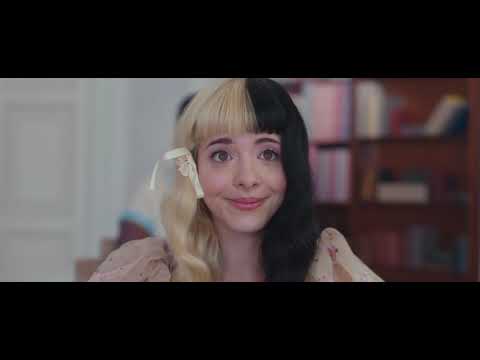 K–12 genre palette — pastel visuals against dark-pop themes, classroom stage with marionette imagery