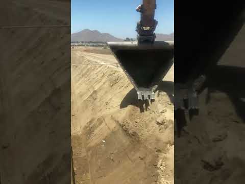 Excavating a sloped trench fast with a V bucket.