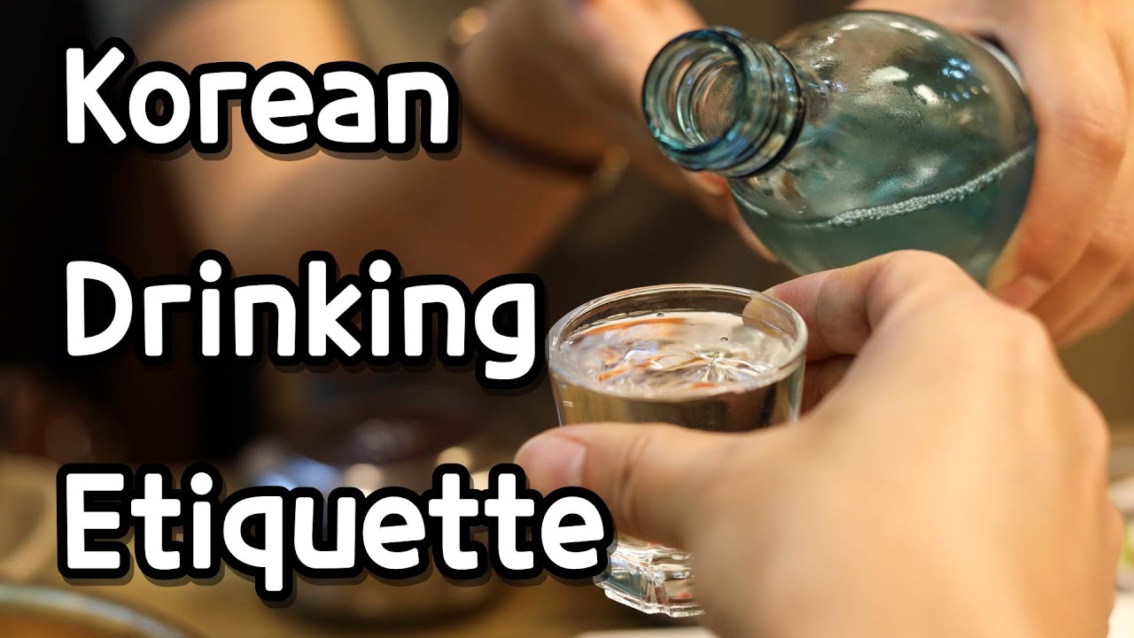 Korean drinking etiquette demonstration showing the two handed soju pour from senior to junior at a dinner table