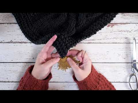 Attaching a tassel to a knitted garment