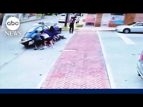 Community members lift car to save e-bike rider