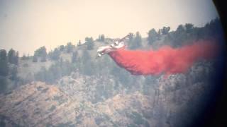 Airplane dropping retardant on forest fire