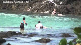 Tourists washed off rocks by big wave