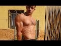Young stud flexing huge shredded muscles after workout