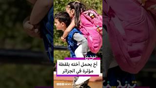 طفل جزائري يحمل شقيقته عائدا من المدرسة