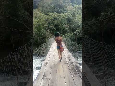 Cruzando un puente colgante sobre el rio Pampa Hermosa, Satipo, Junin, Peru.