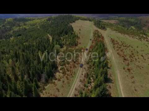 Suv Convoy Traveling Through the Mountains of the Carpathians. the Camera Flies Over the Trees and