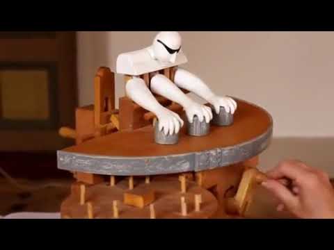 Manually cranked wooden toy does slight of hand magic trick.