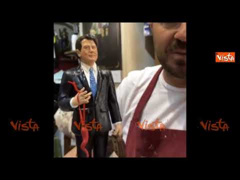 Conte tra le statuine del presepe napoletano con corno portafortuna e valigetta