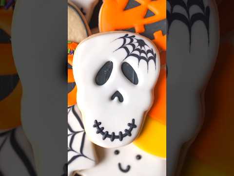 Skull cookie decorated with royal icing with wet on wet spiderweb #halloweencookies #royalicing