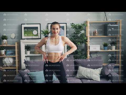 Smiling female bodybuilder looking at camera and moving body showing muscles