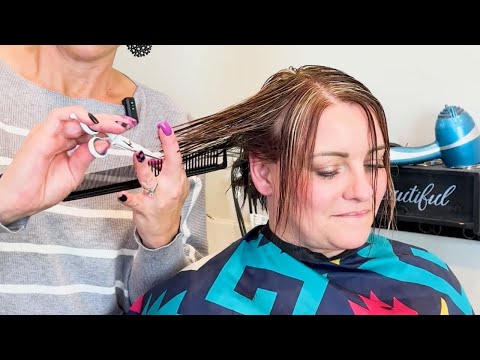 Woman receiving a haircut with scissors, showcasing a layered hairstyle, emphasizing age-appropriate styling for women over 40.