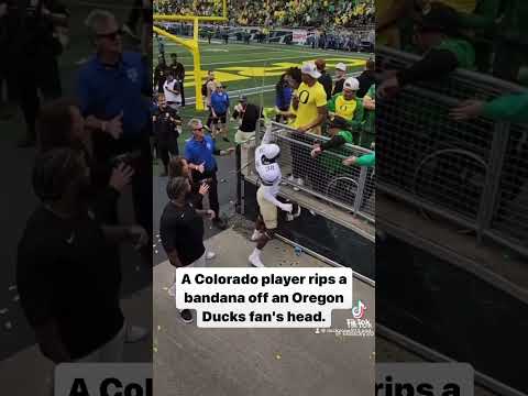 A Colorado player rips a bandana off an Oregon Ducks fan’s head.