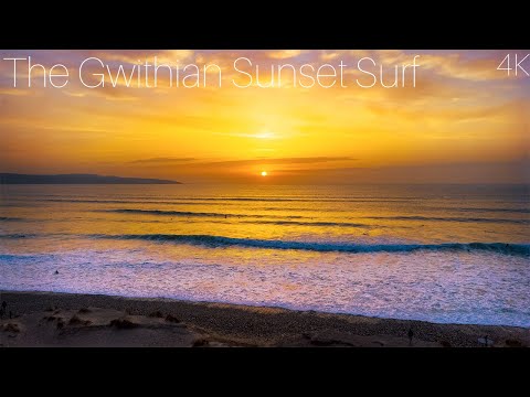 Sunset drone footage ntawm surfers thiab nthwv dej ntawm Gwithian
