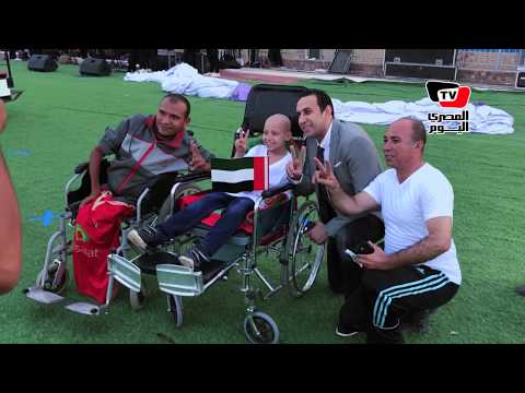 طارق السعيد يجلس على الأرض لالتقاط السيلفي مع أحد مرضى السرطان في «السوبر العربي»