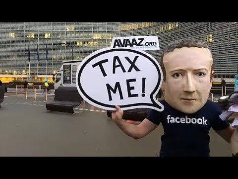 شاهد ممثل يرتدي قناع مارك زوكربيرغ للمطالبة بفرض ضريبة على عمالقة الرقميات…