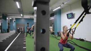 PureGym East Grinstead: Indoor gym area with putting green, lifting racks, weight plates, and rubberized floor.