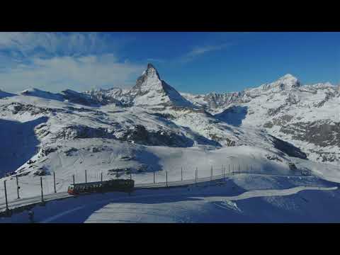 Aerial view of snow mountain range landscape Gornergrat bahn railway running.