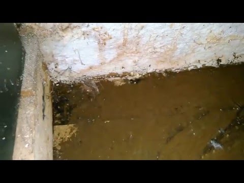 Water pouring through concrete wall