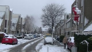 preview picture of video 'Besneeuwde straat met besneeuwde daken en een kerstman hangt in de mast in Spijkeisse'