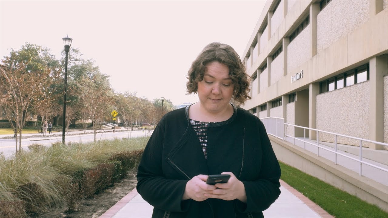 Woman on phone walks through campus